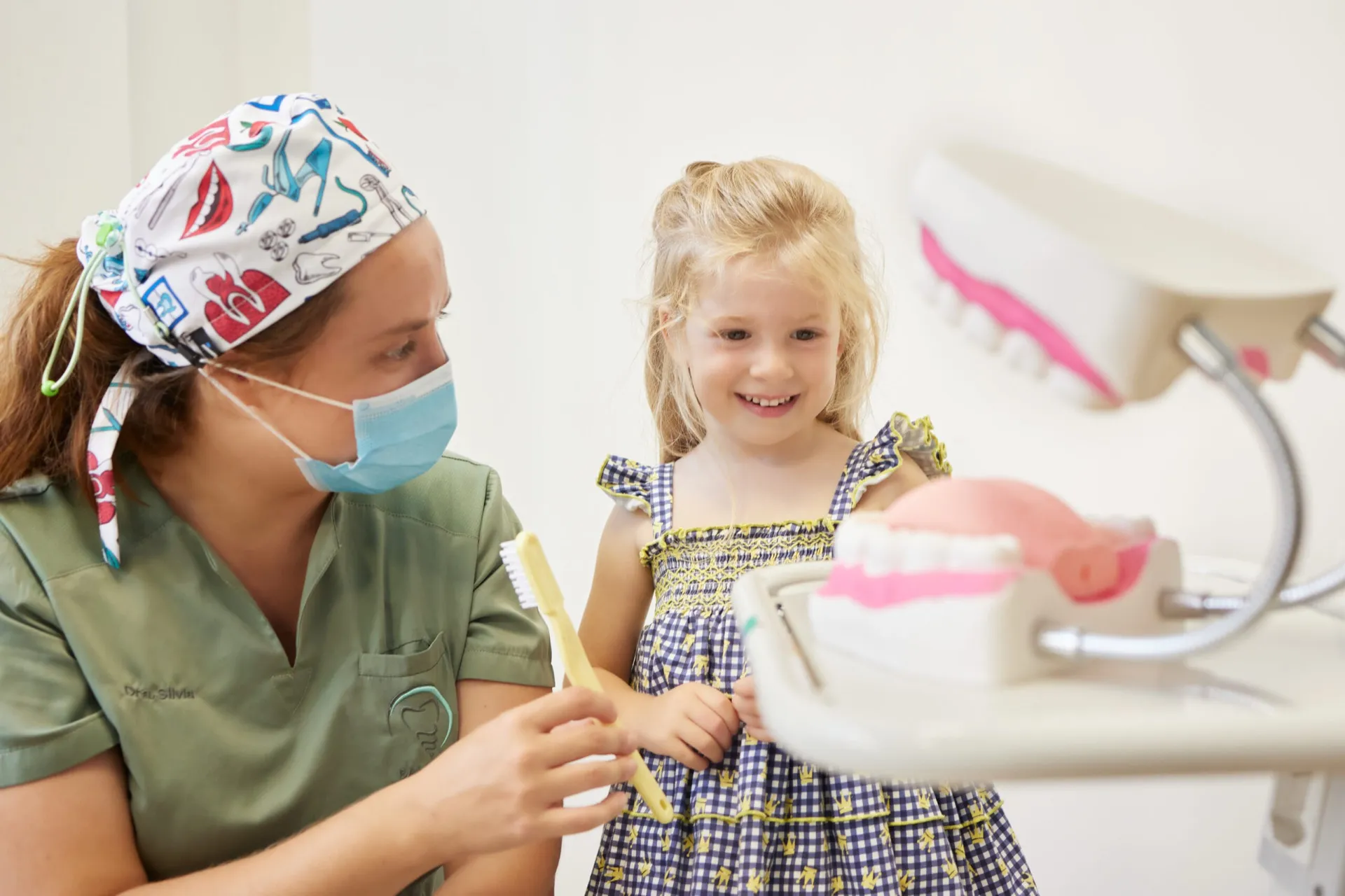 Doctora de Clínica Dental Balaídos enseñando a cepillarse los dientes a una niña