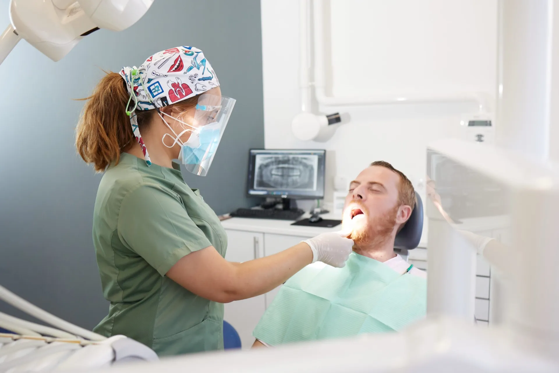 Doctora de Clínica Dental Balaídos realizando una exploración a un paciente en el gabinete