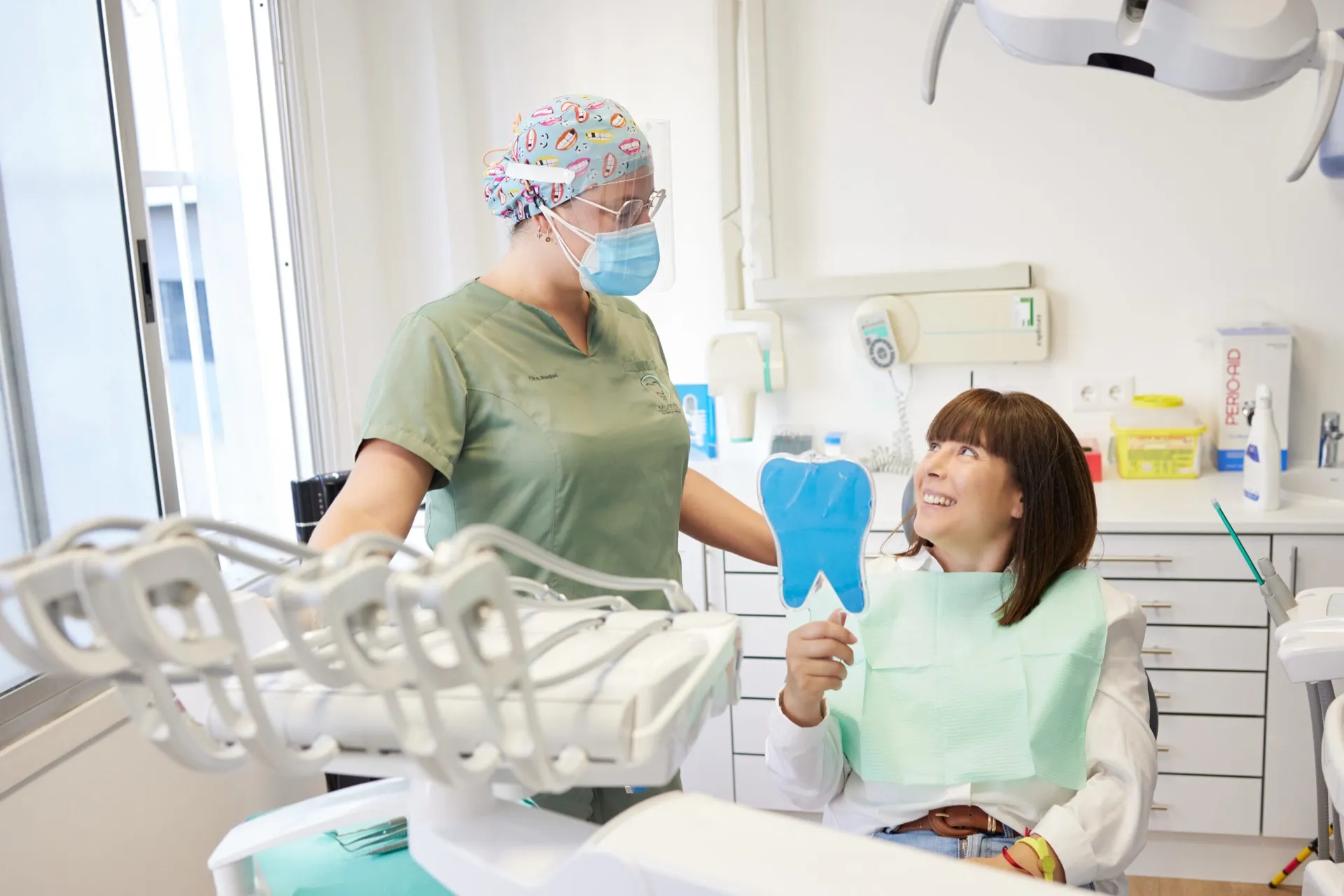 Paciente de Clínica Dental Balaídos mirándose la sonrisa en un espejo con forma de diente
